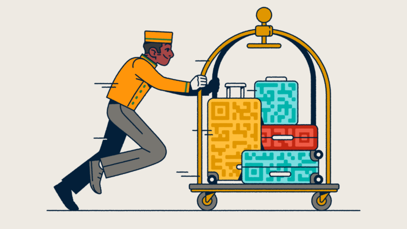 A bellhop pushing a luggage cart with several suitcases that have QR Code prints on them.